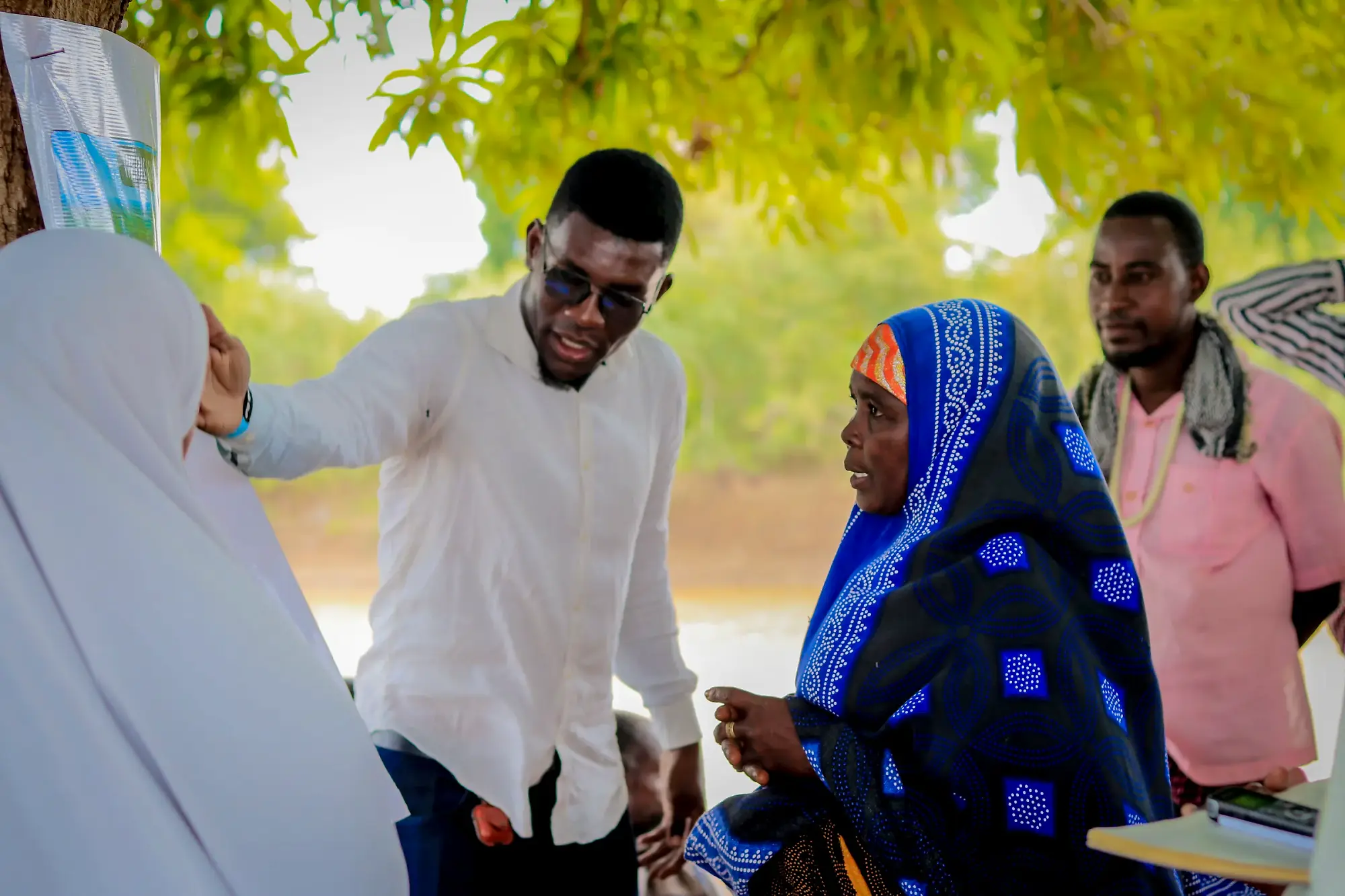A facilitator turns to a woman participant mid-exchange, both gesturing.